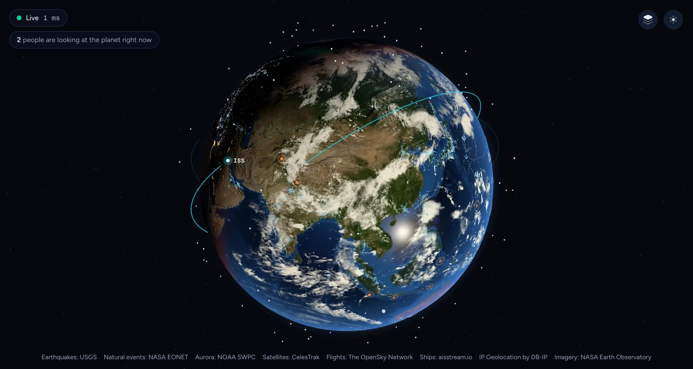 The globe over Asia in daylight, with clouds, the sun glinting on the Pacific, the ISS and its orbit, earthquake rings around Japan and Indonesia, and thousands of tiny aircraft.